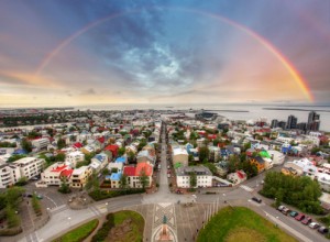 Foto von Reykjavik mit Regenbogen am Himmel.